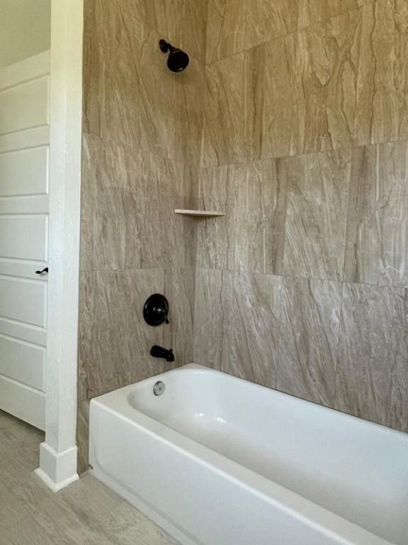 bathroom with tiled shower / bath combo and wood-type flooring