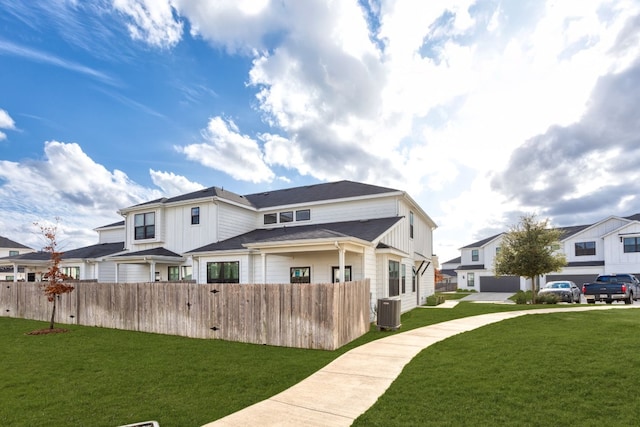 rear view of property with a yard and cooling unit