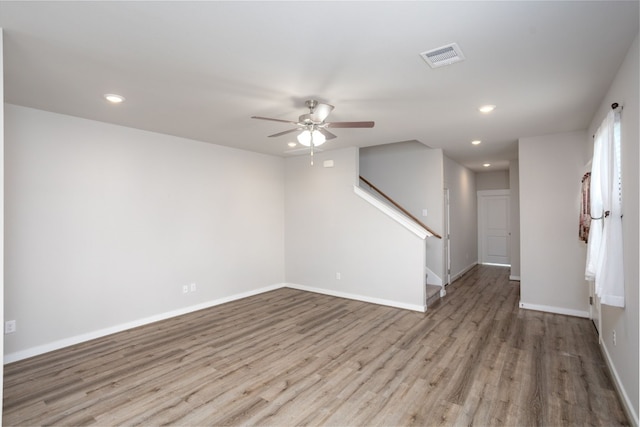 empty room with ceiling fan and light hardwood / wood-style floors