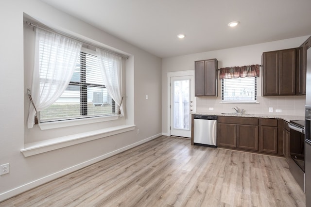 kitchen with light hardwood / wood-style floors, dark brown cabinetry, appliances with stainless steel finishes, and tasteful backsplash