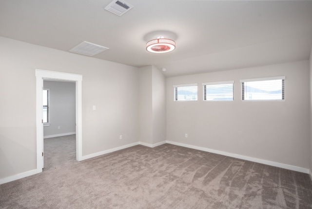 carpeted spare room featuring a healthy amount of sunlight