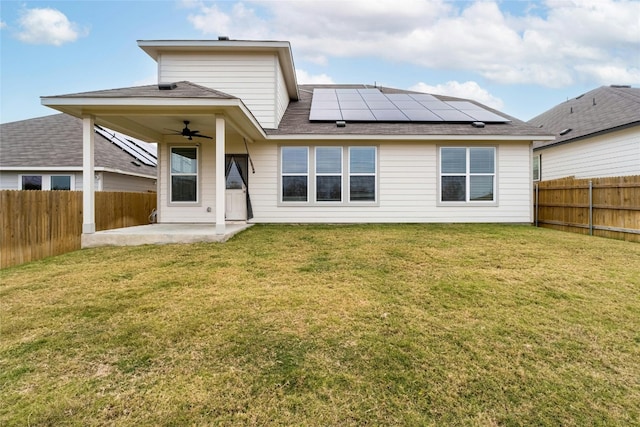 back of house with a lawn, ceiling fan, a patio, and solar panels