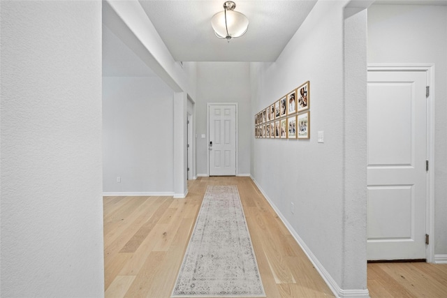 hallway with light hardwood / wood-style floors