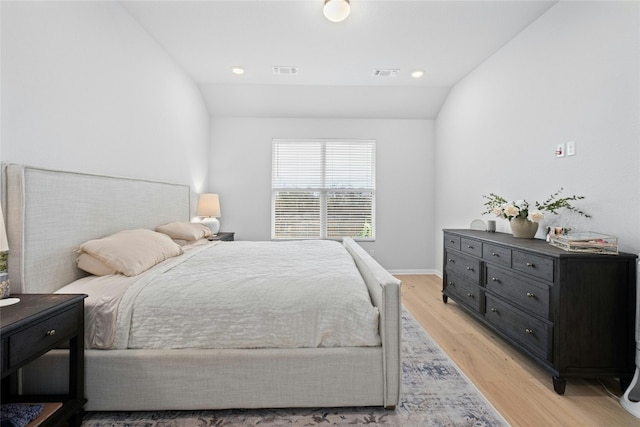 bedroom featuring lofted ceiling and light hardwood / wood-style flooring