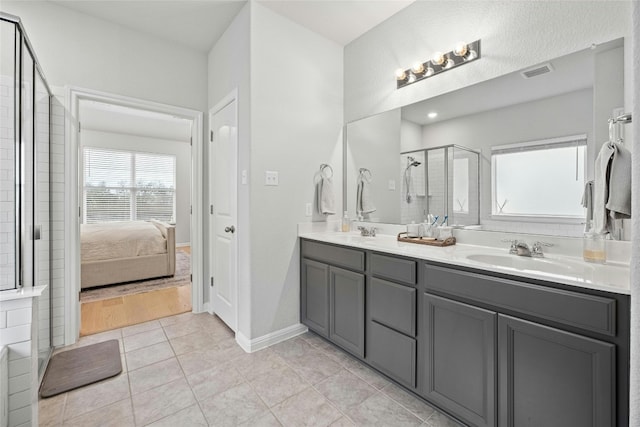 bathroom featuring tile patterned flooring, vanity, and a shower with shower door