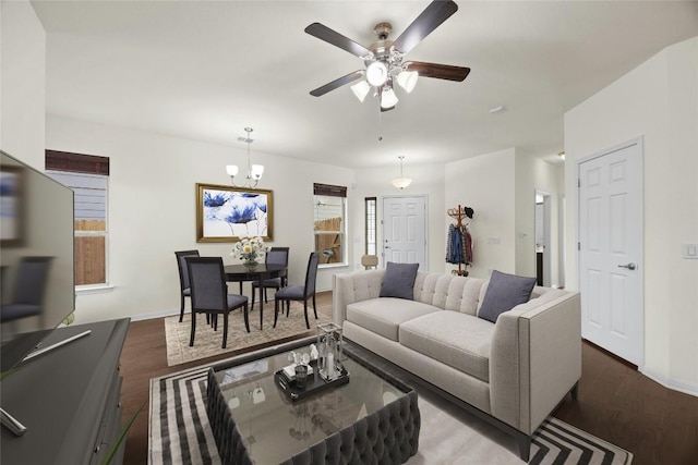 living room featuring ceiling fan with notable chandelier and dark hardwood / wood-style floors