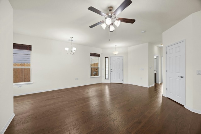 unfurnished living room with ceiling fan with notable chandelier and dark hardwood / wood-style floors