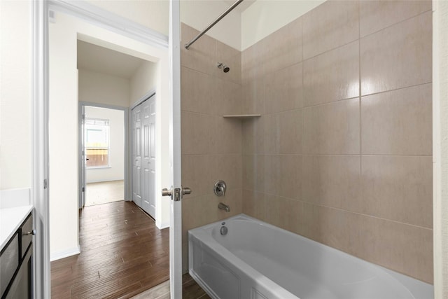 bathroom featuring vanity, wood-type flooring, and tiled shower / bath combo