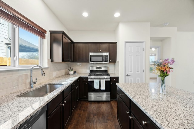 kitchen featuring light stone countertops, appliances with stainless steel finishes, tasteful backsplash, and sink