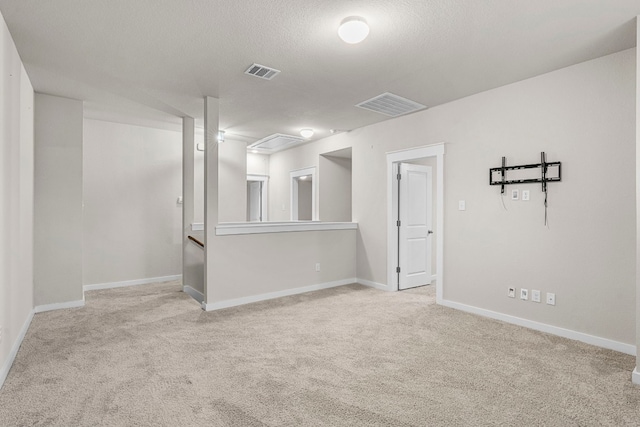 carpeted empty room featuring a textured ceiling