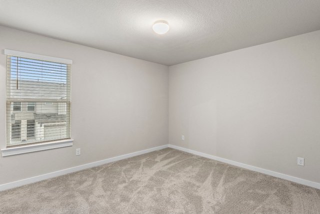 carpeted empty room with a textured ceiling