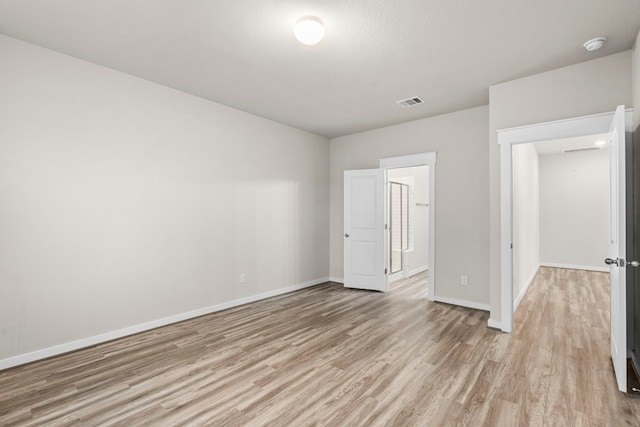 unfurnished bedroom featuring a textured ceiling and light wood-type flooring