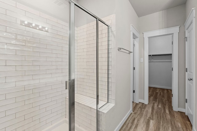 bathroom featuring a shower with door and hardwood / wood-style floors