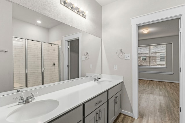 bathroom with vanity, a shower with shower door, and hardwood / wood-style flooring