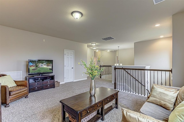 carpeted living room featuring a notable chandelier