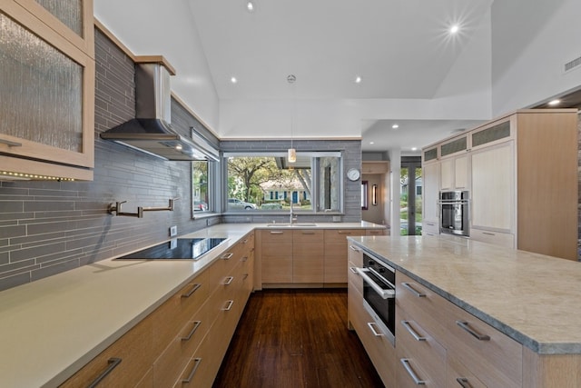 kitchen with dark hardwood / wood-style flooring, black electric cooktop, stainless steel oven, and wall chimney range hood