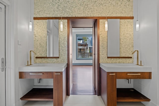 bathroom featuring tile patterned floors, vanity, and tasteful backsplash