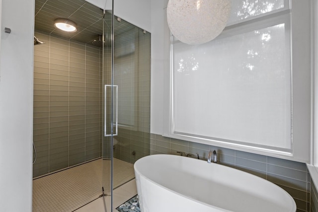 bathroom featuring shower with separate bathtub, tile patterned floors, and tile walls