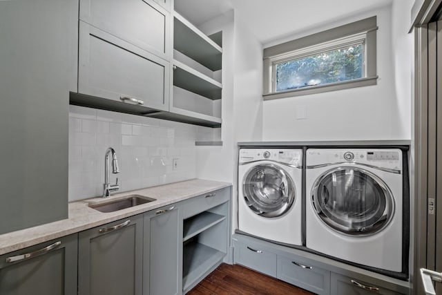 washroom with washer and dryer, cabinets, sink, and dark wood-type flooring