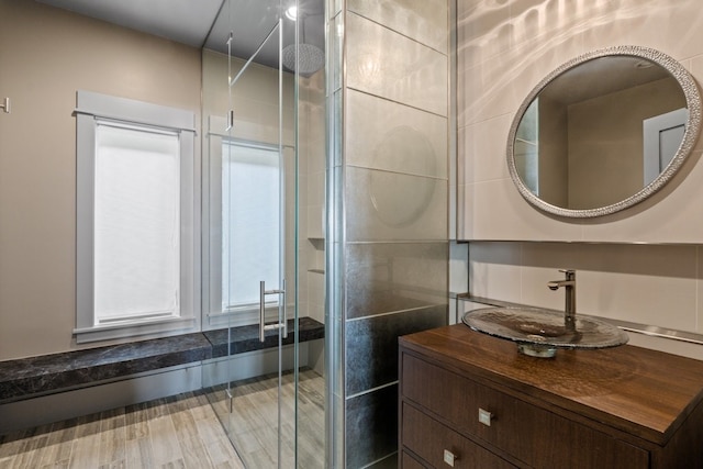 bathroom with vanity, an enclosed shower, and tile walls