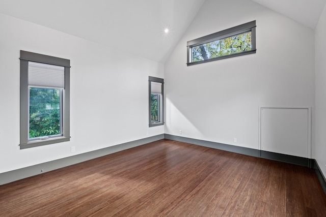 spare room with dark hardwood / wood-style flooring and high vaulted ceiling