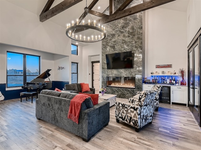 living room with beam ceiling, a fireplace, high vaulted ceiling, and light wood-type flooring