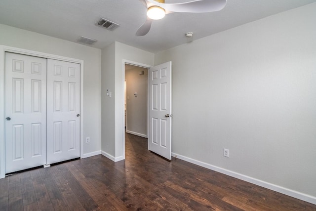 unfurnished bedroom with ceiling fan, dark hardwood / wood-style flooring, and a closet