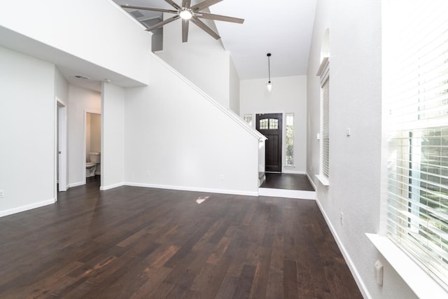 foyer entrance featuring ceiling fan, dark hardwood / wood-style flooring, and a high ceiling