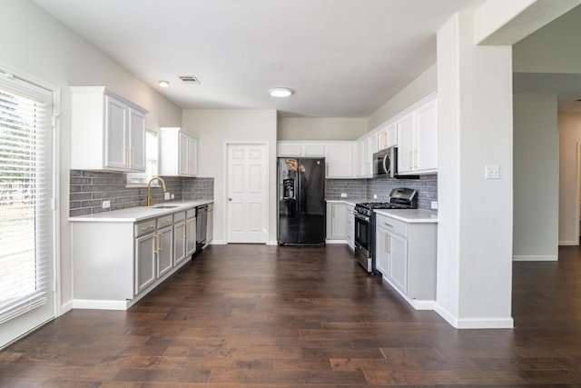 kitchen featuring appliances with stainless steel finishes, dark hardwood / wood-style flooring, tasteful backsplash, sink, and white cabinetry