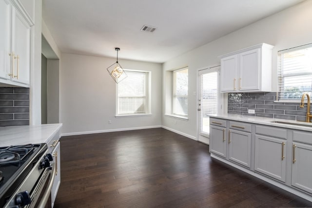 kitchen featuring sink, hanging light fixtures, dark hardwood / wood-style floors, decorative backsplash, and white cabinets