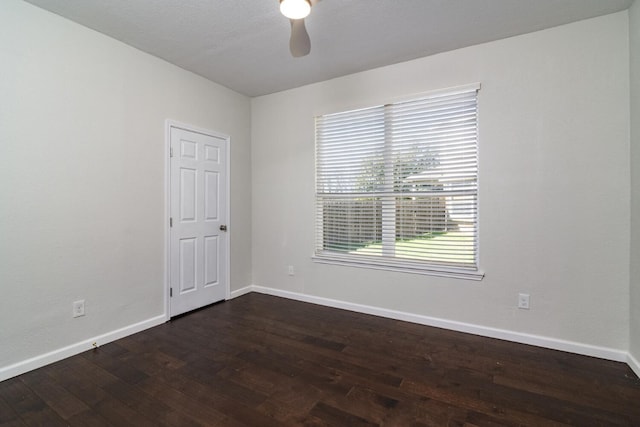 empty room with dark hardwood / wood-style floors and ceiling fan