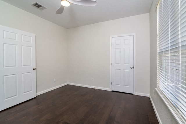 empty room with dark hardwood / wood-style floors and ceiling fan