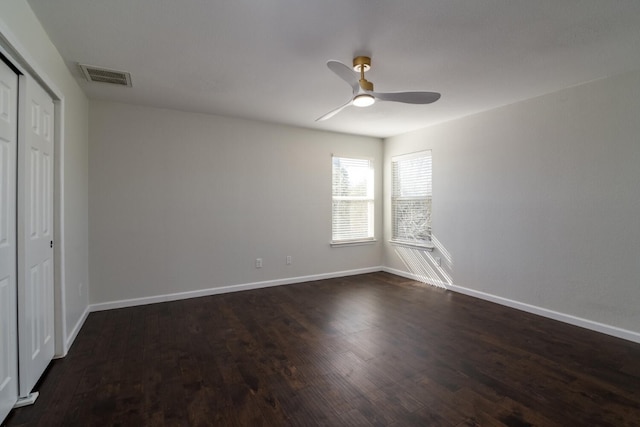 unfurnished bedroom featuring dark hardwood / wood-style flooring, a closet, and ceiling fan