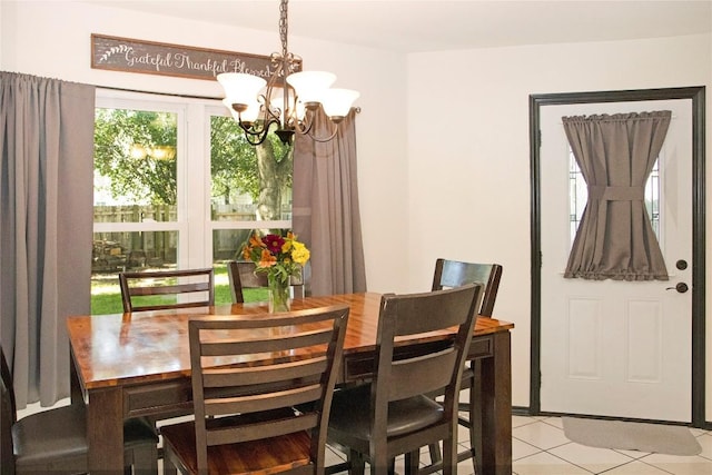 dining area with light tile patterned flooring and an inviting chandelier