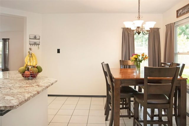 tiled dining space featuring a chandelier