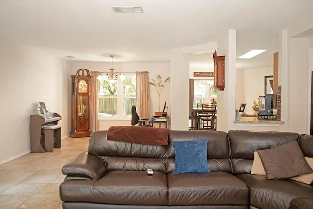 living room with light tile patterned floors and an inviting chandelier