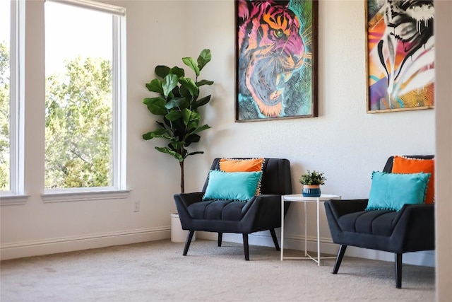 living area featuring light carpet and baseboards