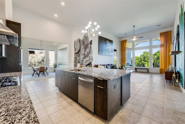 kitchen with appliances with stainless steel finishes, open floor plan, pendant lighting, and dark brown cabinets