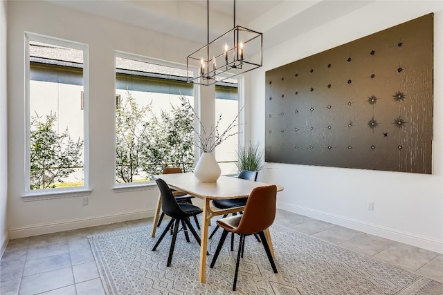 dining space with a notable chandelier, baseboards, and light tile patterned floors