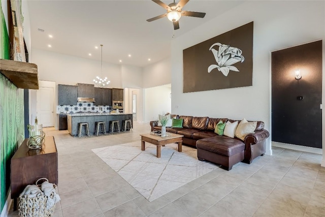 living area featuring recessed lighting, light tile patterned flooring, ceiling fan, and a towering ceiling