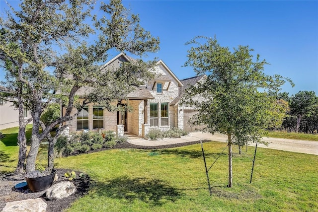 view of front of home with a garage, stone siding, a front lawn, and concrete driveway