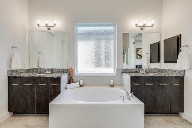 full bathroom featuring two vanities, plenty of natural light, and tile patterned floors