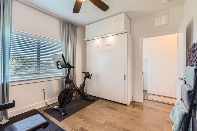 exercise room featuring ceiling fan and light wood-type flooring