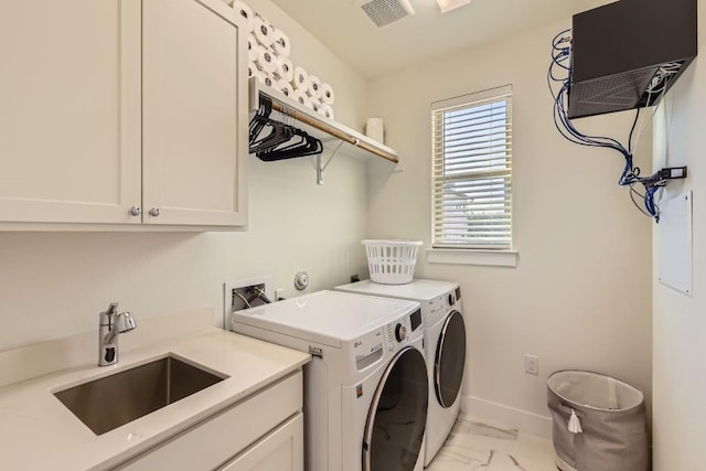 washroom with sink, washer and clothes dryer, and cabinets