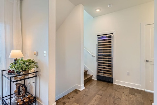 corridor with hardwood / wood-style flooring and beverage cooler