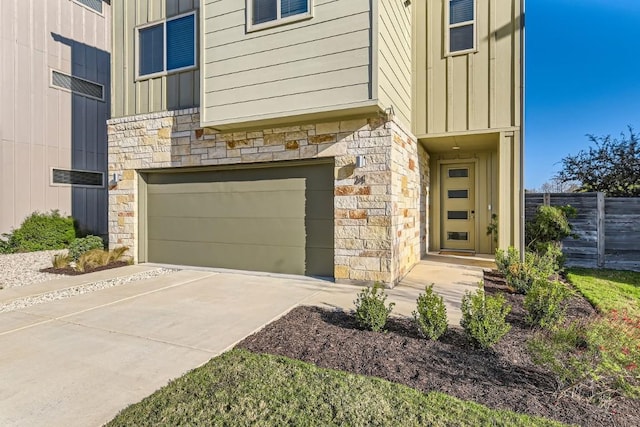5315 La Crosse Ave Unit 24, Austin, TX 78739 - view of exterior entry with stone siding, an attached garage, board and batten siding, and concrete driveway