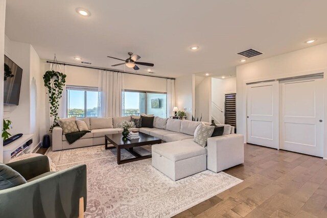 living room with ceiling fan and light wood-type flooring