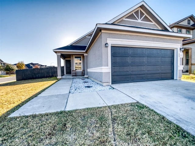view of front of property featuring concrete driveway, stucco siding, an attached garage, a front lawn, and fence