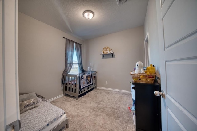 carpeted bedroom featuring visible vents, baseboards, and a textured ceiling