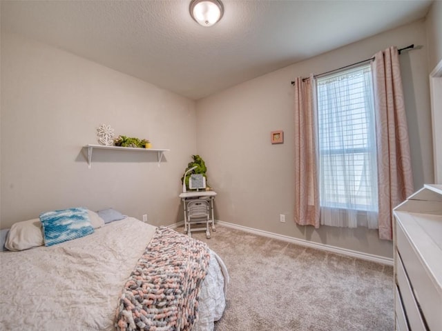 carpeted bedroom featuring a textured ceiling and baseboards